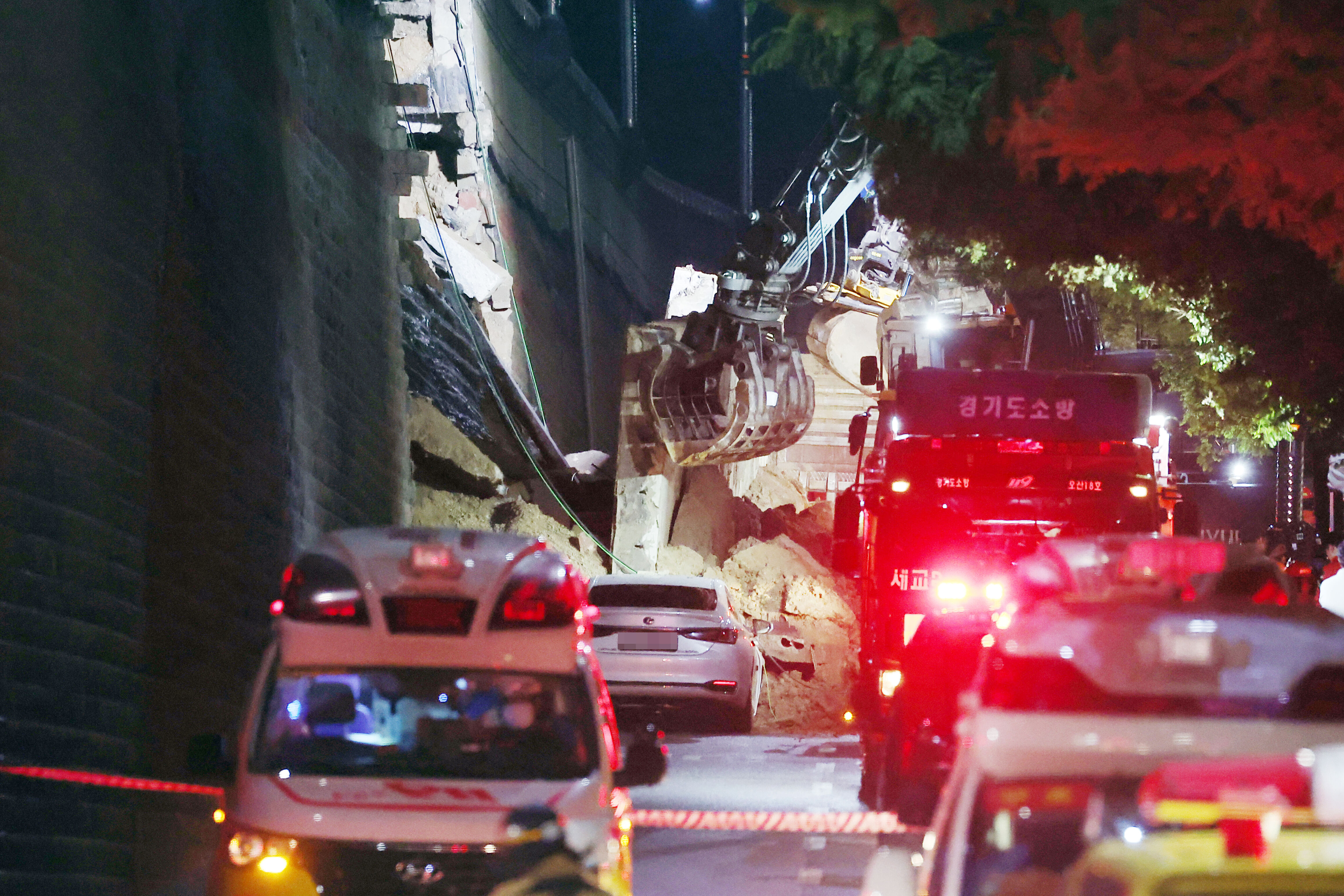 ▲▼南韓京畿道烏山市16日暴雨來襲，白色轎車行駛高架橋旁，遭擋土牆崩塌活埋。（圖／達志影像／newscom）