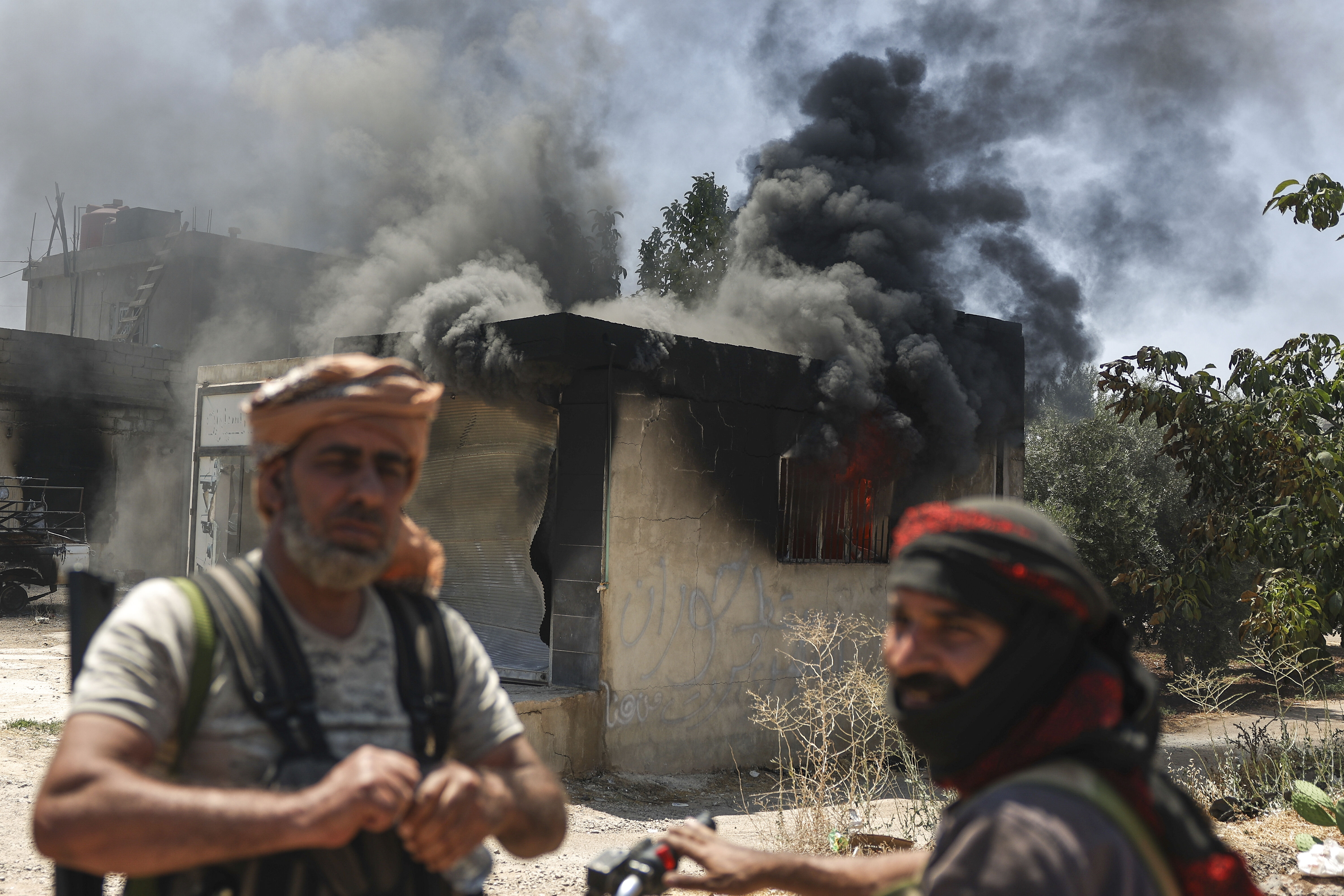 ▲▼7月18日，在敘利亞南部貝都因部落與德魯茲民兵發生衝突期間，貝都因戰士站在蘇韋達市郊區一家被燒毀的商店前。（圖／達志影像／美聯社）