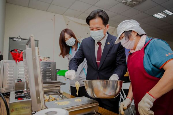 ▲代理市長邱臣遠與志工學習手做蛋捲。（圖／新竹市政政府提供）
