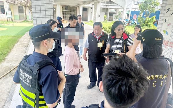 ▲桃園市中壢區內壢國小今天上午夏姓婦人投票時，因不耐排隊怒撕選票，選監人員與警方攔下。（圖／記者沈繼昌翻攝）