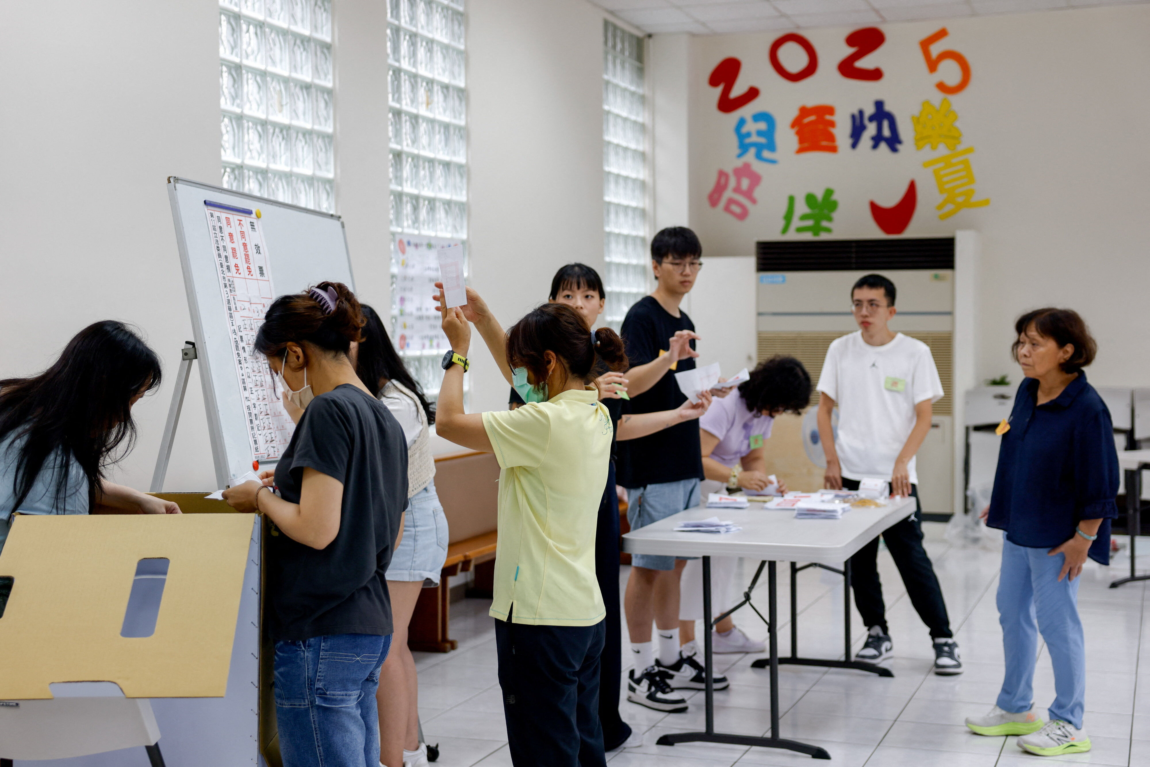 ▲▼台北某選區的民眾26日前往投票所進行「大罷免」投票。（圖／路透）
