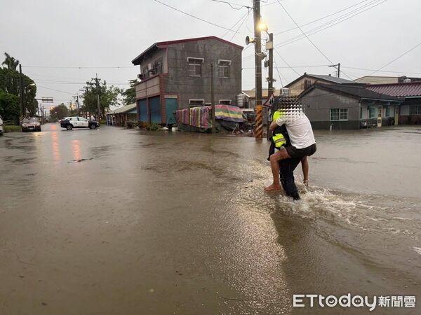 ▲白河分局警方涉水進入民宅，背出受困長者，畫面溫馨動人。（記者林東良翻攝，下同）