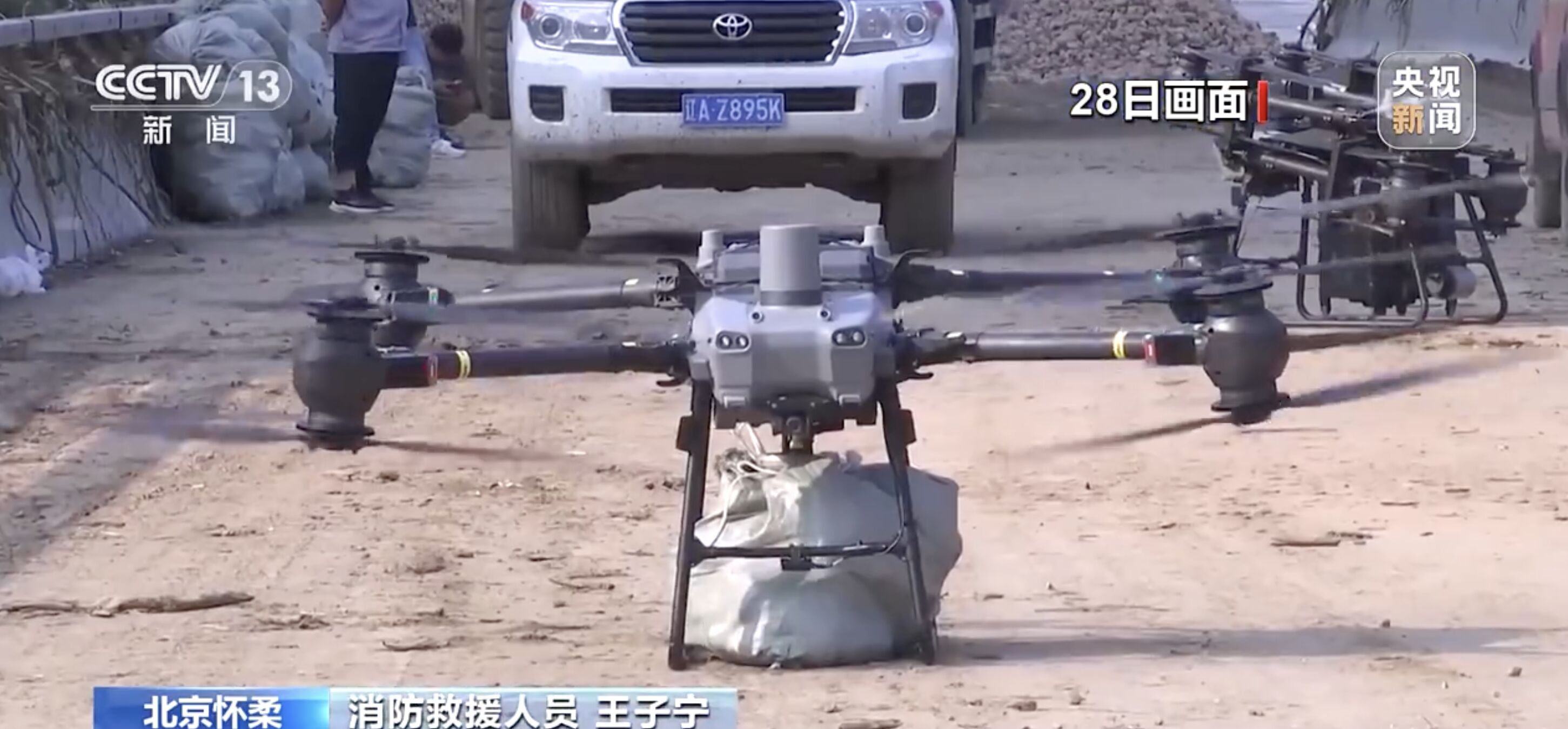 ▲北京消防救援人員動用無人機向受困災民空投食物。（圖／翻攝央視）