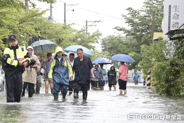 ▲台南市長黃偉哲2日上午身穿青蛙裝，前往安南區北安路積水封鎖區勘災。（記者林東良翻攝，下同）