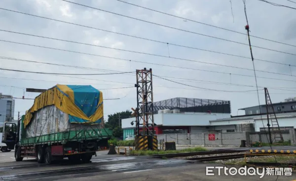 ▲▼一輛卡車行經平交道時，貨物過高卡住，司機處理時不慎感電。（圖／讀者提供）