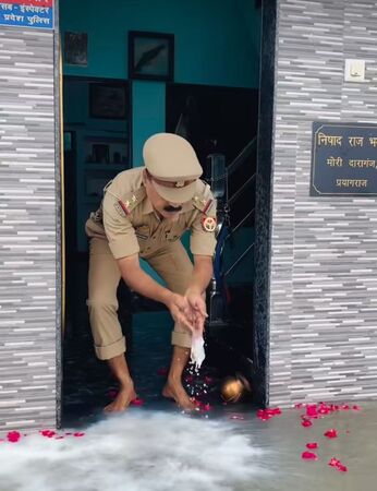▲▼恆河水上漲，印度北方邦一名警察把洪水視為「聖物」。（圖／翻攝自Chandradeep Nishad/Instagram）