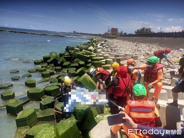▲台南消防隊員與特搜隊合作，在退潮後將溺水男子浮屍成功打撈上岸。（記者林東良翻攝）