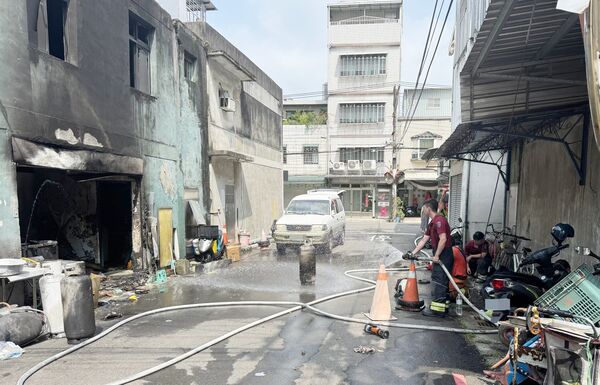▲桃園市中壢區華勛街一處民宅今天下午發生瓦斯氣爆引發火警案，警消將屋內瓦斯桶拖出戶外沖水降溫。（圖／中壢警方提供）