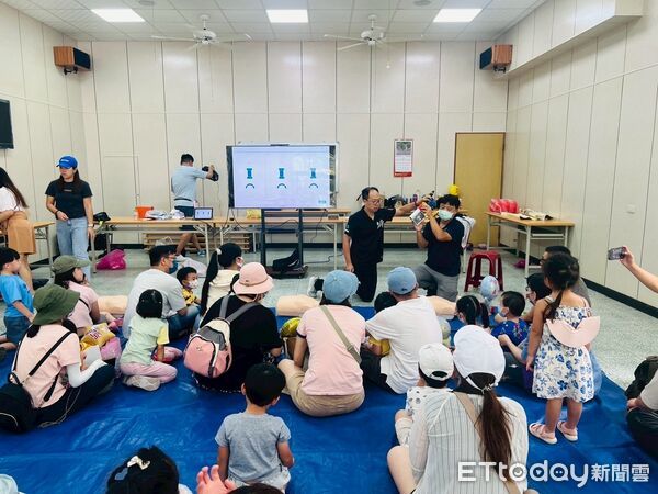 ▲消防員帶著小朋友體驗迷你版消防衣與滅火射水，寓教於樂學防災。（記者林東良翻攝，下同）