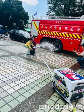 ▲消防員帶著小朋友體驗迷你版消防衣與滅火射水，寓教於樂學防災。（記者林東良翻攝，下同）