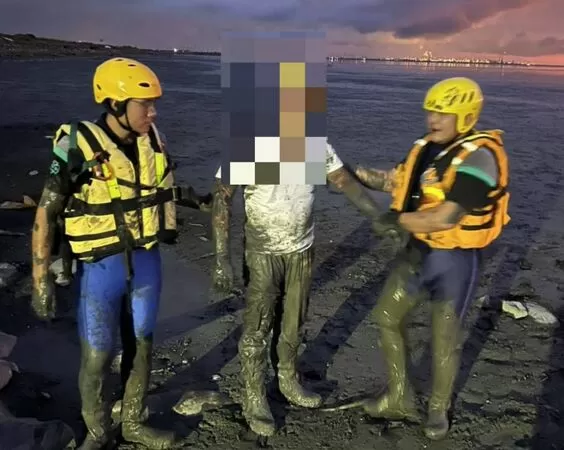 ▲遊客拍海堤夕陽深陷泥灘消防搶救。（圖／民眾提供）