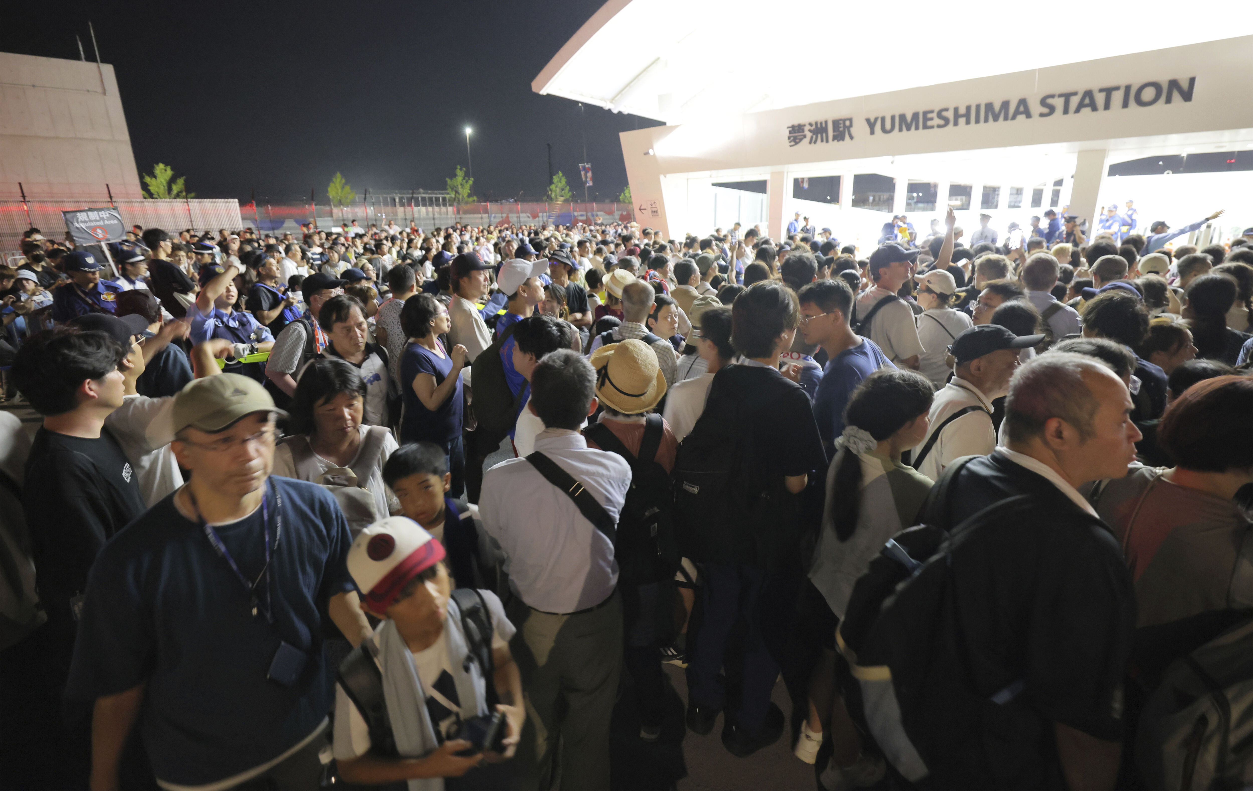 ▲▼大阪地鐵中央線13日晚間因停電而停駛，導致大阪世博大批遊客受困在夢洲車站前。（圖／達志影像／美聯社）