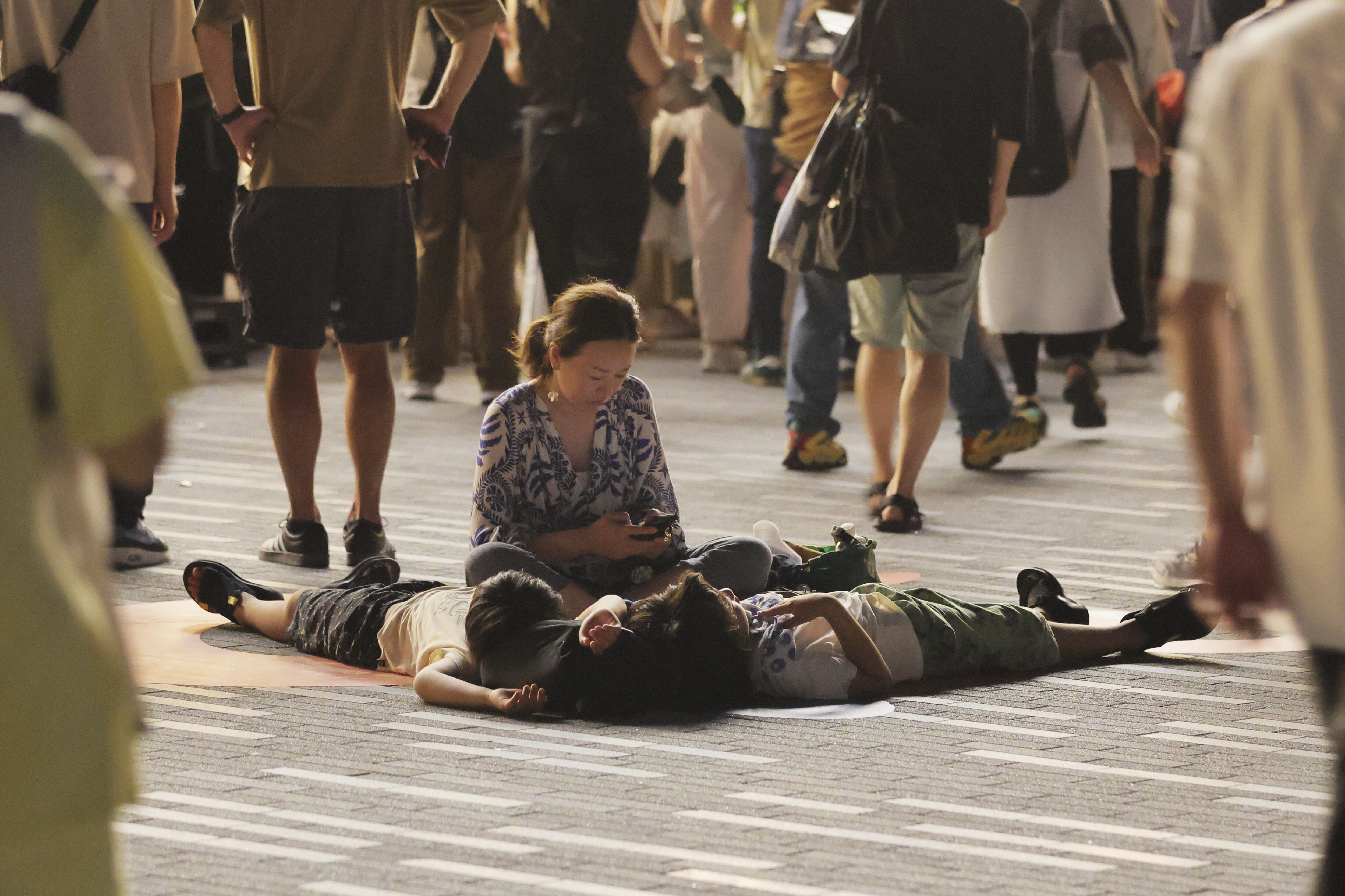 ▲▼大阪地鐵停駛，受困的大阪世博遊客只能苦中作樂。（圖／達志影像／美聯社）