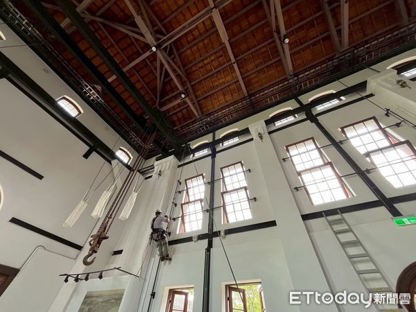 ▲高空繩索技師宛如「蜘蛛人」攀升古蹟屋樑，更換燈泡與清理牆面，場面難得一見。（記者林東良翻攝，下同）