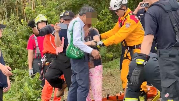 ▲王女人車墜谷被救出，與趕來的丈夫呂男（穿灰上衣）擁抱。（圖／民眾提供）