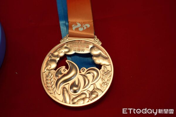 ▲114全國運動會在雲林。縣府18日舉行「114年全國運動會獎座獎牌暨貴賓、隊職員伴手禮露出發表記者會」，展出團體獎獎座、獎牌、公仔與伴手禮 。（圖／記者游瓊華翻攝）