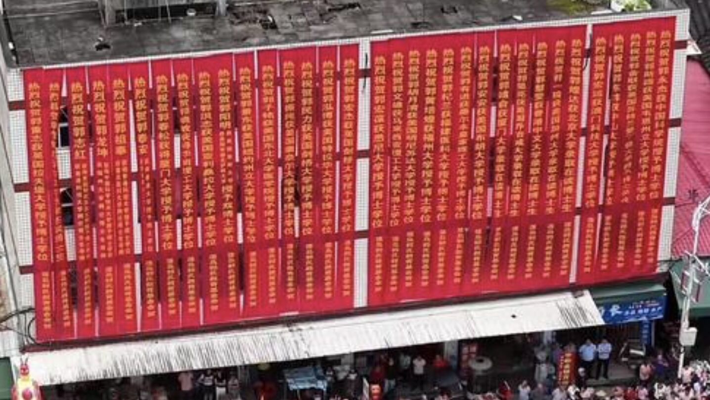 ▲福建南安「博士村」內的一棟建築上掛著一橫排高中博士的紅色祝賀彩聯。（圖／翻攝瀟湘晨報）