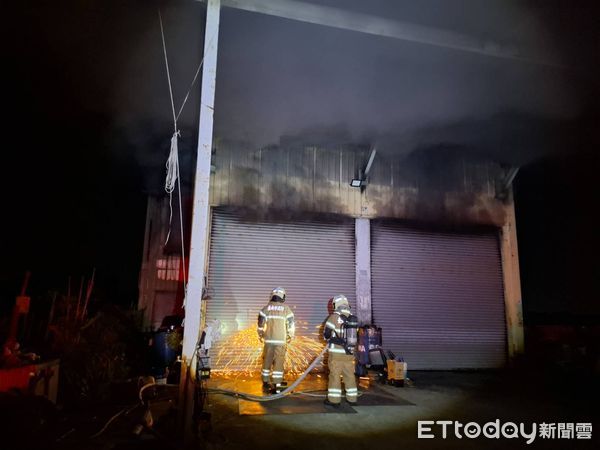 ▲台南官田區鐵皮工廠22日深夜突發火警，消防人員破門布線射水全力搶救。（記者林東良翻攝，下同）