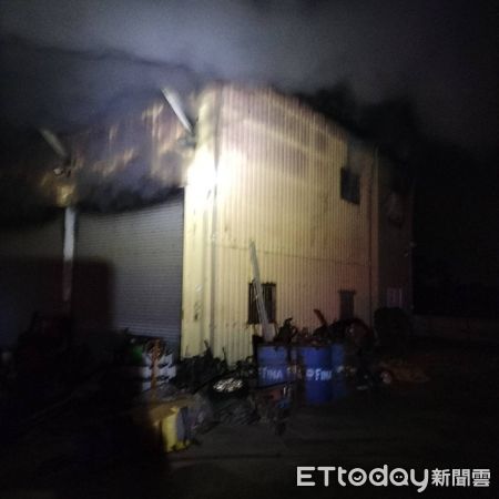 ▲台南官田區鐵皮工廠22日深夜突發火警，消防人員破門布線射水全力搶救。（記者林東良翻攝，下同）