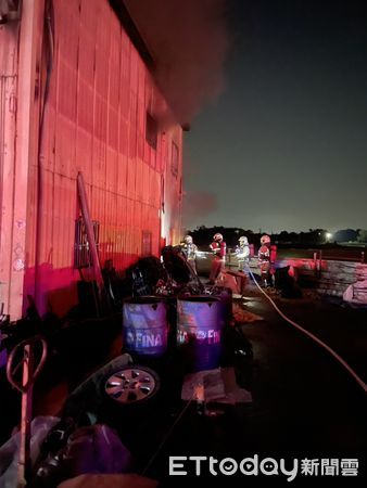 ▲台南官田區鐵皮工廠22日深夜突發火警，消防人員破門布線射水全力搶救。（記者林東良翻攝，下同）