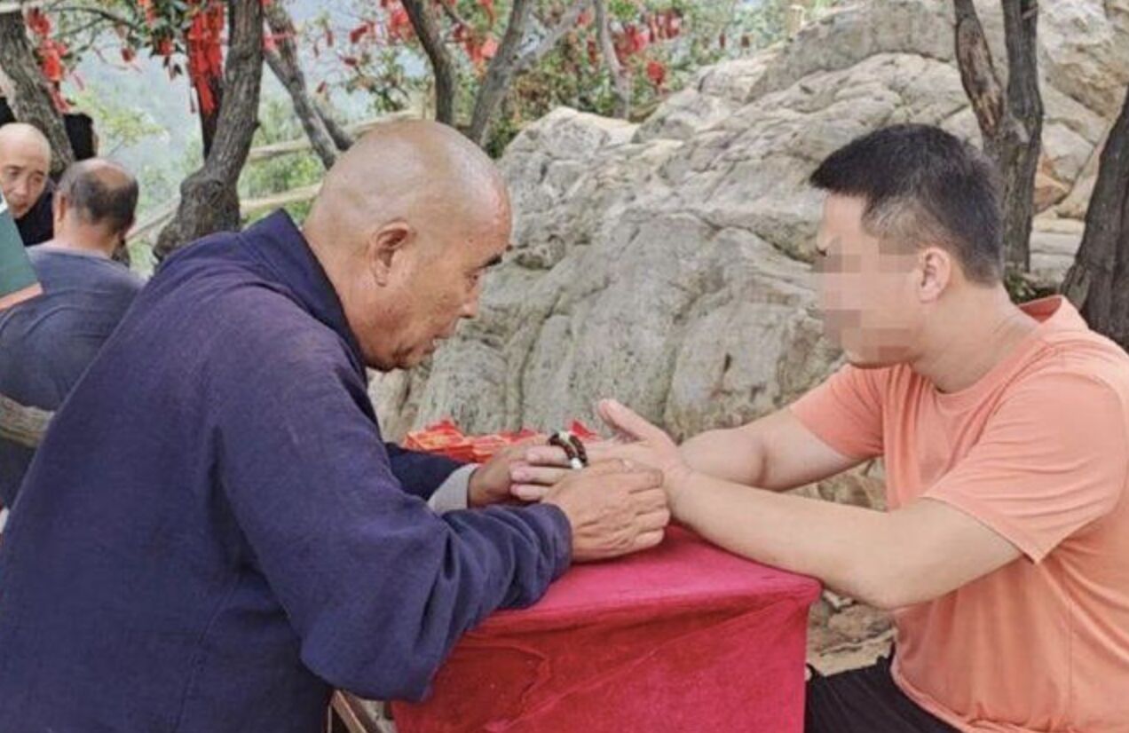 ▲少林寺外有身著僧人服飾的攤商替人算卦。（圖／翻攝奔流新聞）