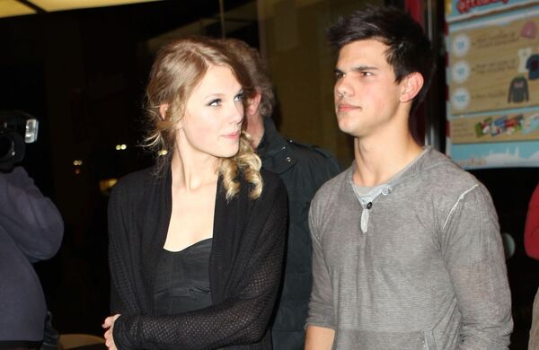 2009年泰勒絲（左）與泰勒洛納（右）曾短暫交往過，當時泰勒絲露出不想被拍到的表情。（東方IC）