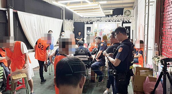 ▲桃園市警局督察室日前會同中壢警方在中壢區健行路某大樓破獲推筒仔職業賭場，員警現場逐一清查賭客身分。（圖／中壢警方提供）