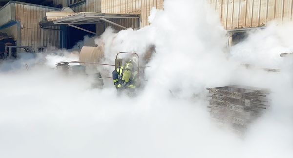 ▲桃園市新屋區埔工路一處液態工廠8月26日下午發生二氧化碳外洩意外，消防人員穿戴防護衣衝入白色煙霧中搶救。（圖／桃園市消防局提供）