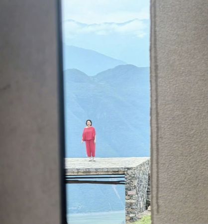 林青霞穿著紅衣，在壯麗山景前，相當醒目。（翻攝小紅書）