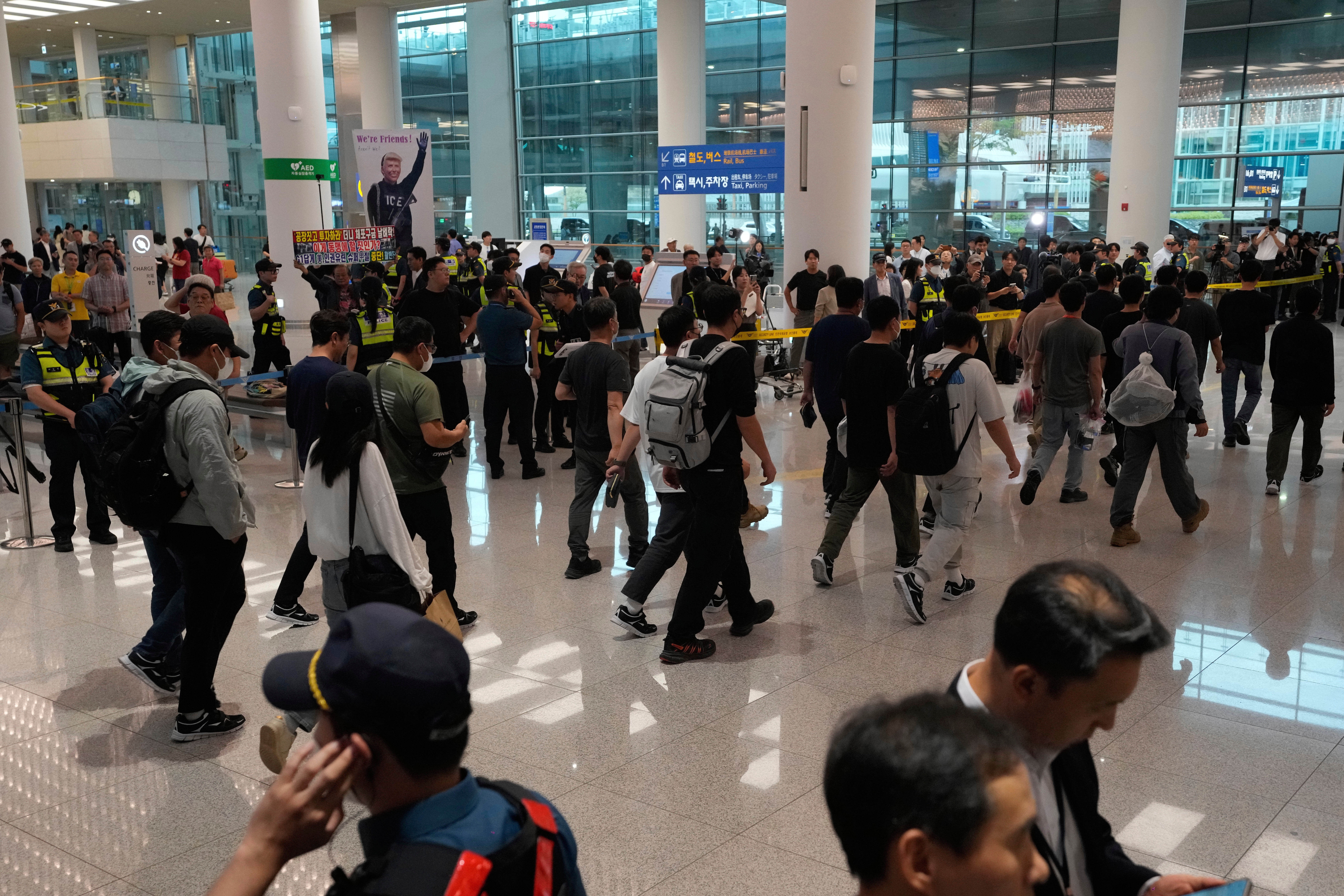 ▲▼遭美國移民當局拘留數日的韓籍勞工，12日下午搭乘南韓政府包機返抵仁川機場。（圖／達志影像／美聯社）