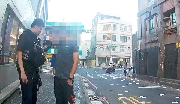 ▲桃園市江姓男子昨天傍晚在桃園區某私校前拋撒傳單，引發師生抗議，桃園警方到場處理。（圖／桃園警方提供）