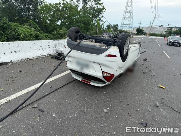 ▲台南市佳里區麻佳路發生自小客車翻覆事故，消防人員出動搶救史姓駕駛脫困送醫。（記者林東良翻攝，下同）