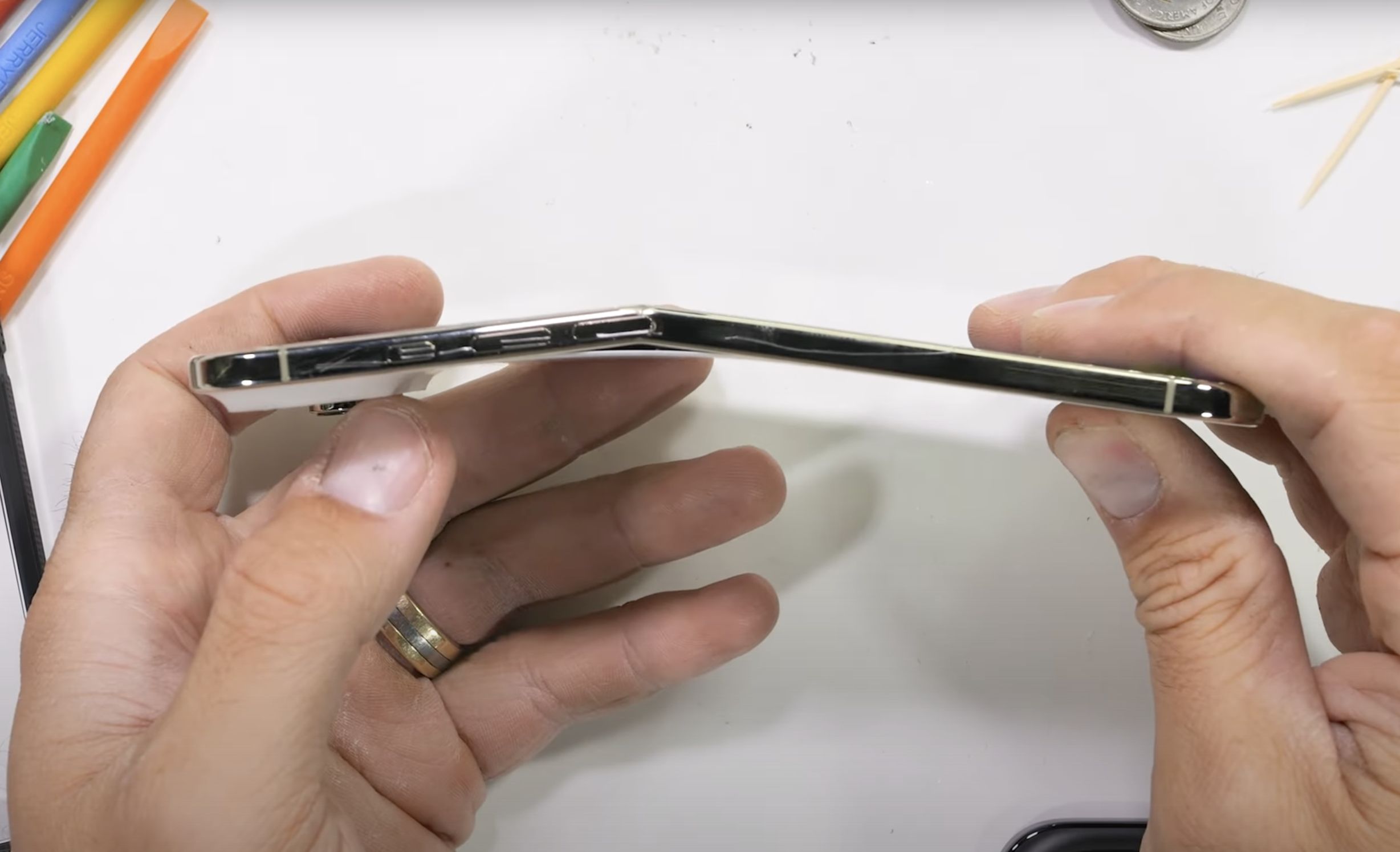 ▲iPhone Air在極端重力測試下出現斷裂聲，但只有機身彎曲，並沒有裂開成兩半。（圖／翻攝YouTube「JerryRigEverything」）