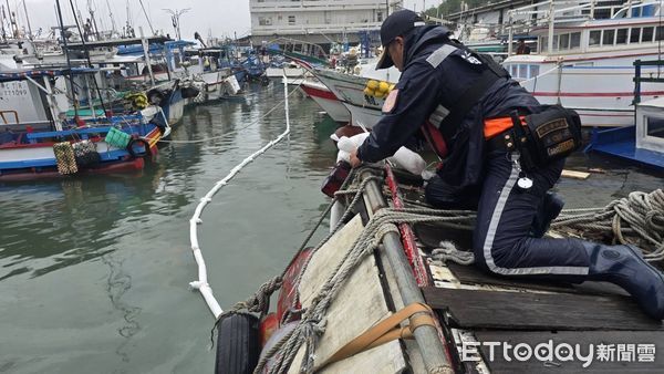 ▲台東富岡漁港內漁船半沉柴油外洩，海巡人員使用棉片和攔油索阻止燃油污染擴大 。（圖／記者張君豪翻攝）
