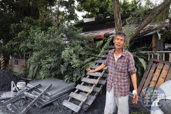 王先生背後的棧板，讓很多人能爬到屋頂，得以生還。