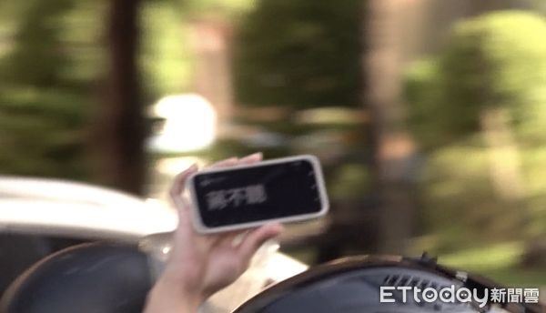 ▲機車族不滿塞車，舉手機抗議「蔣不聽」。（圖／記者黃國霖攝影）