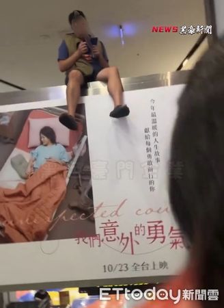 ▲▼高雄一名男子在影城看電影使用手機，螢幕太亮遭後方觀眾抗議，雙方發生糾紛。男子情緒不佳離場後，竟賭氣坐在放映廳外手扶梯旁的懸空平台。（圖／記者吳世龍翻攝）