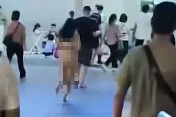 1名妙齡女子全身赤裸，從廣場狂奔至關閘出入境事務站出境入口。（翻攝畫面）