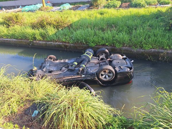 ▲▼自小客車衝落排水溝四輪朝天，消防員搶救受傷女駕駛。（圖／讀者提供，下同）