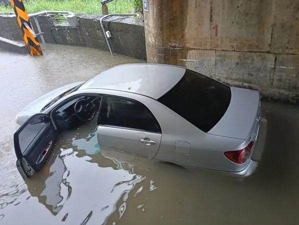 ▲風神颱風大雨，宜蘭頭城外澳接天宮附近道路一輛轎車水淹半個車身，車主PO說「屌車阿！」。（圖／擷取自臉書《宜蘭大小事》）