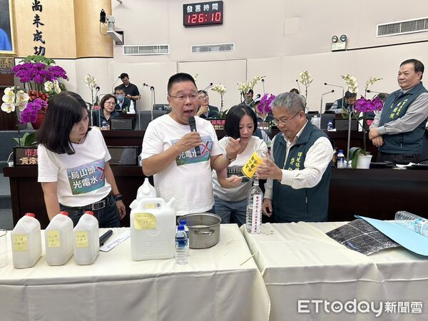 ▲台南市議員蔡育輝等人質詢時敲碎光電板，投入烏山頭水庫水樣中，請市長黃偉哲簽名封存3個月後檢驗。（記者林東良翻攝，下同）