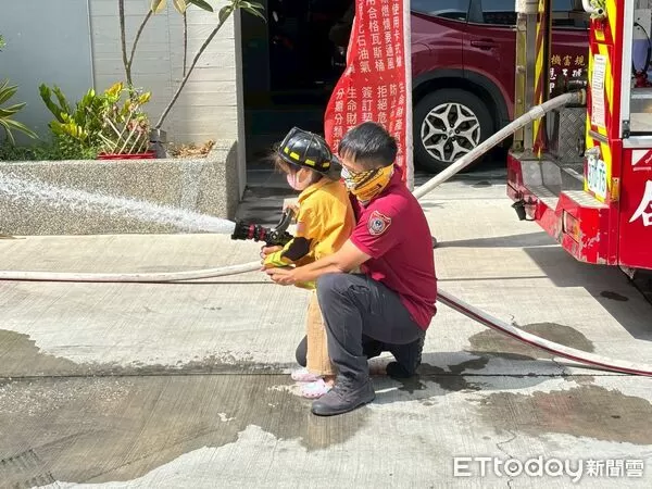 ▲小朋友穿上消防衣，在消防員指導下學習正確射水方式，體驗成為「小小救火英雄」的興奮時刻。（圖／記者林東良翻攝，下同）