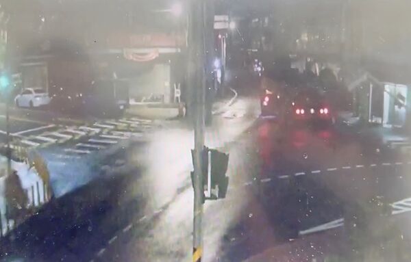 ▲一輛砂石車今天清晨5時許行經龜山區自強北路右轉時，忘記收下車斗防塵網，導致勾倒路旁紅綠燈，圖為監視器勾倒瞬間畫面。（圖／龜山警方提供）