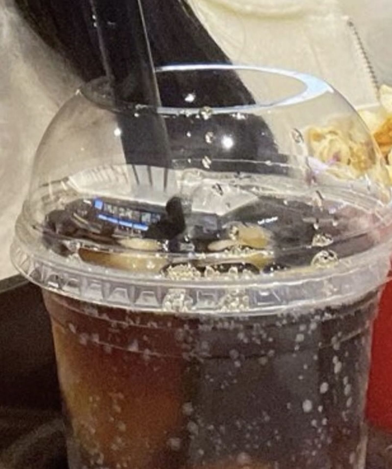 藤咲梓拿著的塑膠飲料杯上有反射，疑似出現短髮男性，她後來遭到許多網友留言攻擊。（翻攝網路）