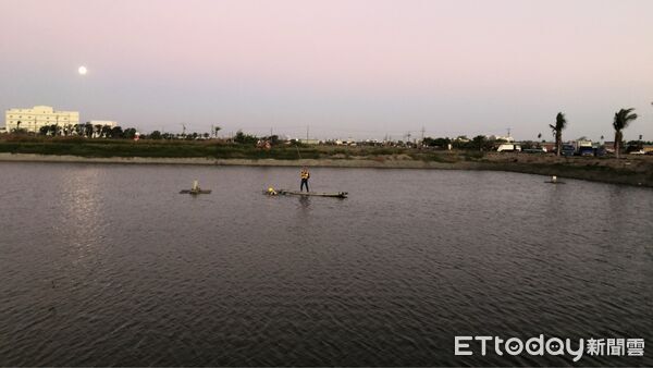 ▲台南七股一名78歲老翁下午疑為處理魚塭風車卡住失足落水，消防局出動消防人員在筏上及派潛水員下水搜尋中。（記者林東良翻攝，下同）