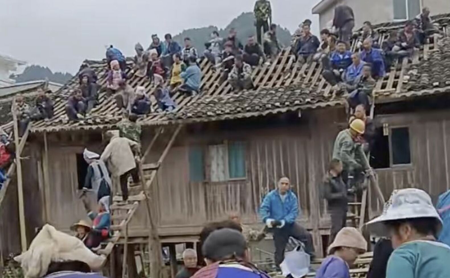 ▲貴州榕江縣平寨村百餘村民將整間吊腳樓抬起搬離。（圖／翻攝極目新聞）