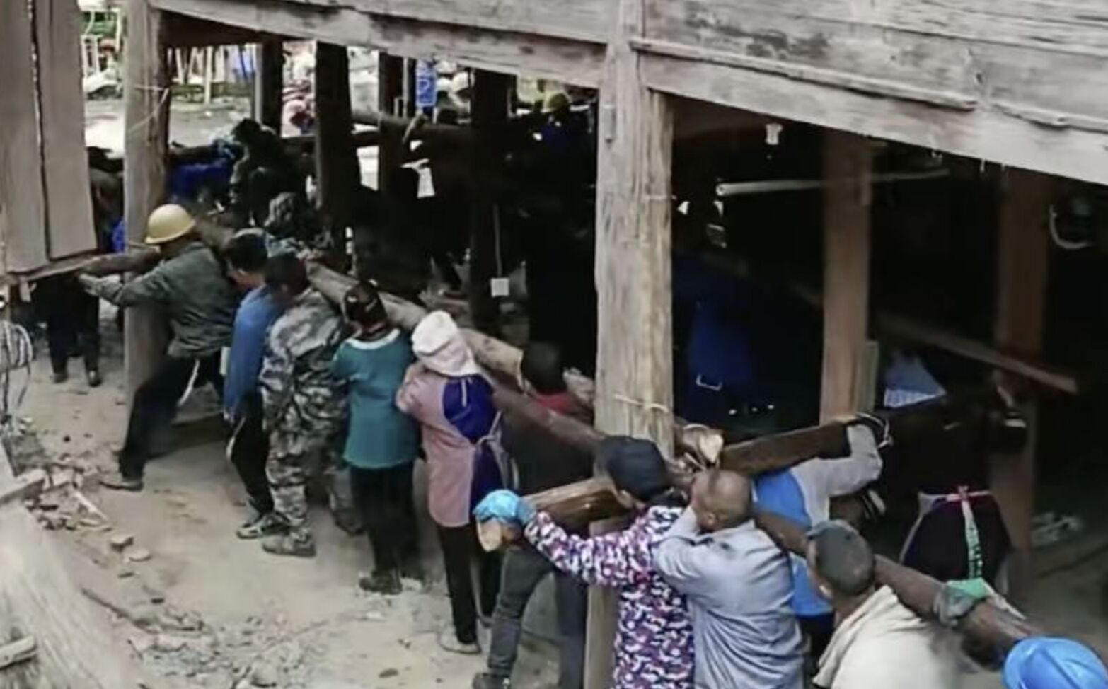 ▲貴州榕江縣平寨村百餘村民將整間吊腳樓抬起搬離。（圖／翻攝極目新聞）