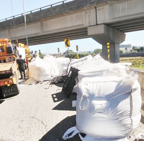 ▲國2大竹交流道匝道今天上午大貨車散落大量太空包，警方找來吊車協助搬運。（圖／國道一隊提供）