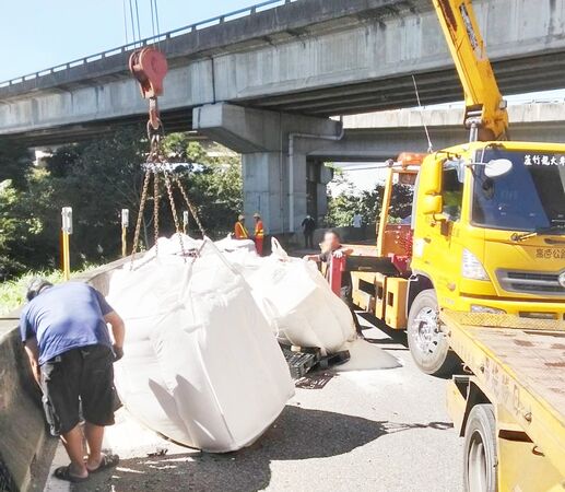 ▲國2大竹交流道匝道今天上午大貨車散落大量太空包，吊車搬運太空包。（圖／國道一隊提供）