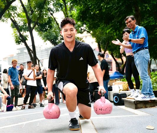 ▲許孟哲下場與民眾PK挑戰、壯壯示範壺鈴弓步走動作要領。（圖／TPF提供）